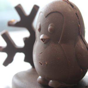 Pingouin en chocolat posé sur une banquise avec un flocons